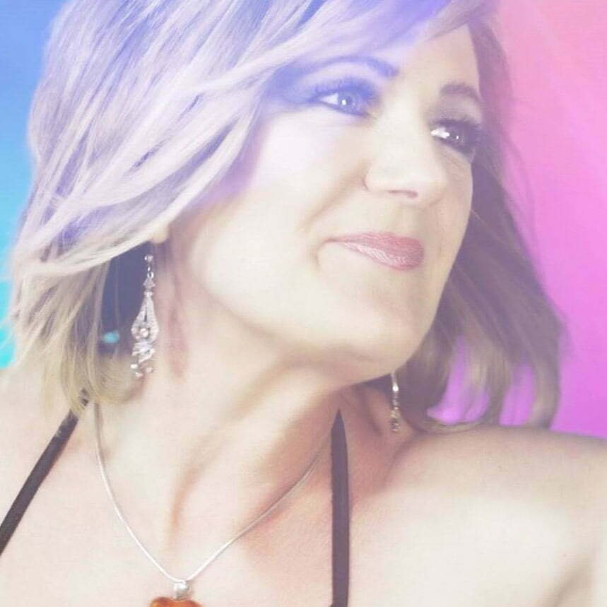 Nicki French close-up image with a blue and pink/purple background.